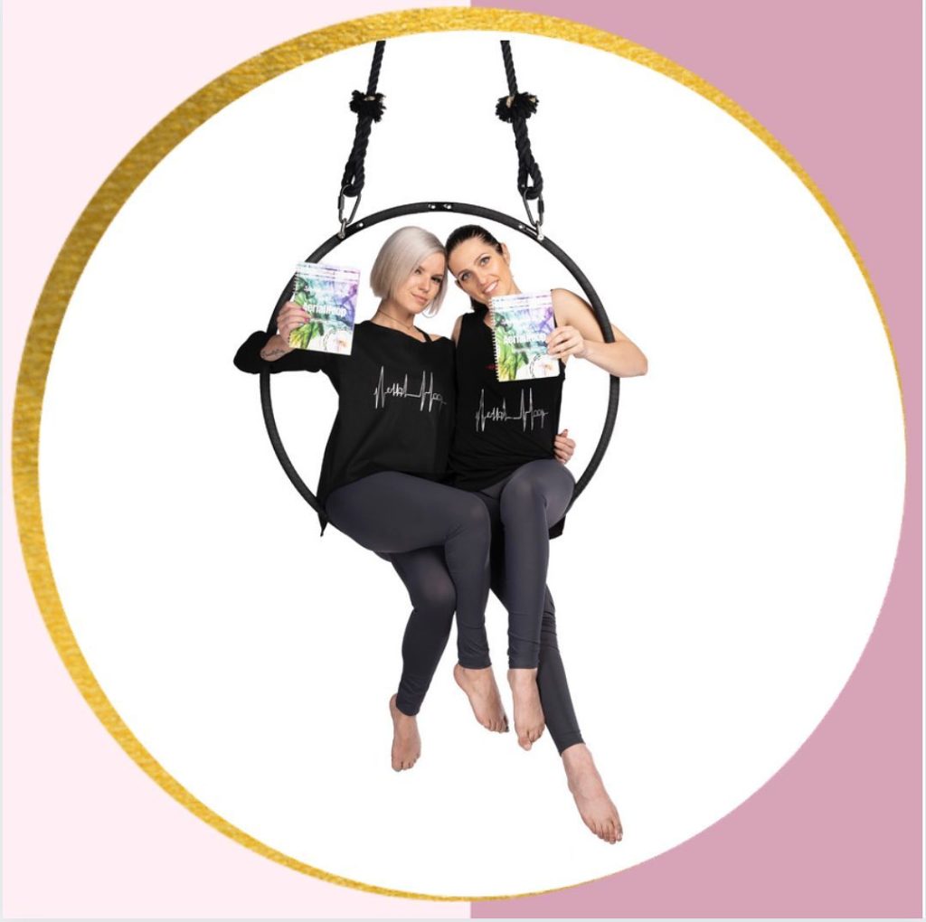 Deux artistes assises dans le cerceau aérien